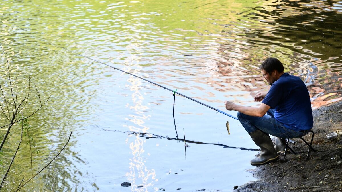    Мужчина ловит рыбу на берегу реки Исеть в Екатеринбурге© РИА Новости / Павел Лисицын