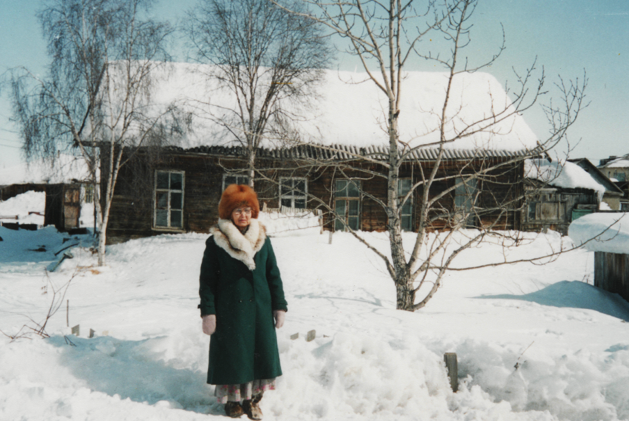 Один из немногих сохранившихся с конца XIX века лиственничных домов. Участница хора «Марковские вечёрки» Вера Прокопьевна Брагина («Отец — юкагир, мать — чуванка, по старому паспорту —  ламутка» — со слов Веры Прокопьевны.) Марково, апрель 2000 г. Фото Т.С. Шенталинской