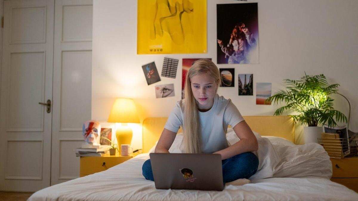    Девочка-подросток сидит в кровати с ноутбуком:Pexels