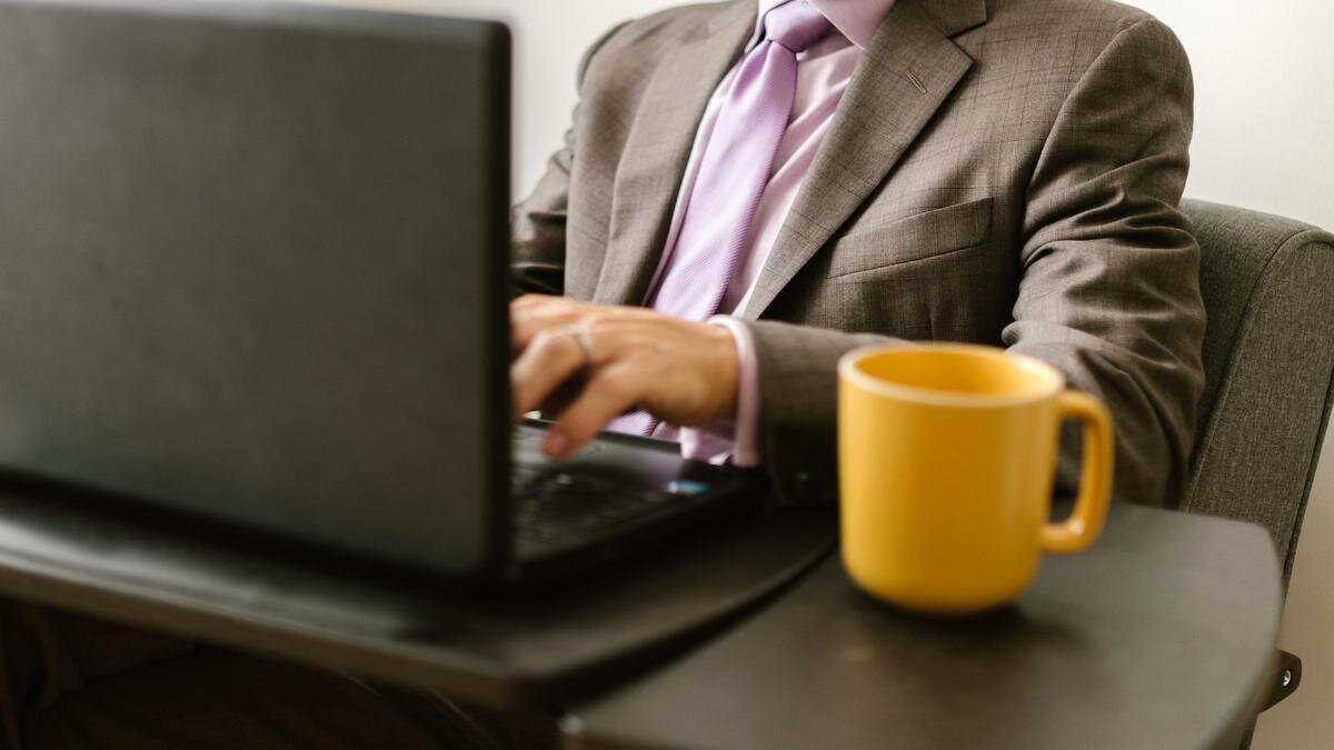    Мужчина в костюме сидит за ноутбуком:pexels.com
