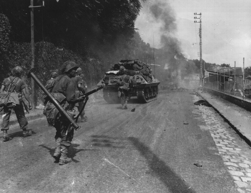 Пехотинцы одной из стрелковых рот 5-й пехотной дивизии американской армии продвигаются под прикрытием самоходных орудий М10 818-го противотанкового батальона в районе коммуны Фонтенбло в регионе Иль-де-Франс; август 1944-го года