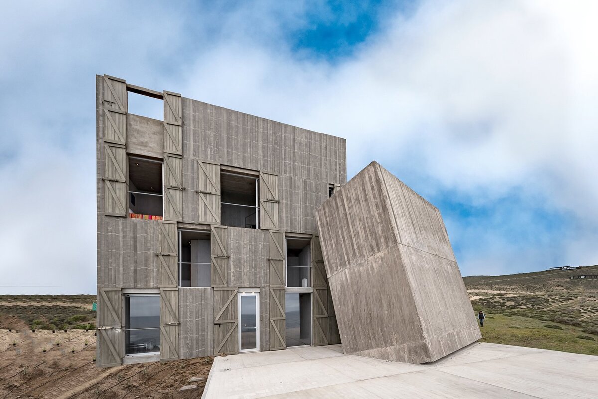 Два из выветрившихся бетонных объемов опираются друг на друга, как строительные блоки. Основной объем распространяется на четыре уровня. 