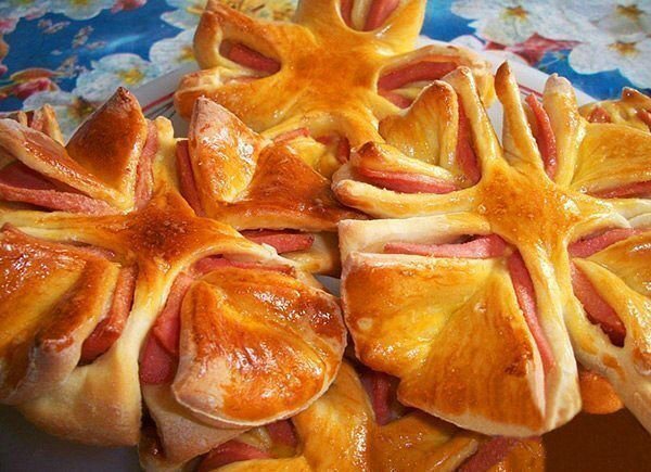 Способ приготовления: 
1. Делаем дрожжевое тесто по любому рецепту или же тесто в хлебопечке или же берем готовое слоеное или слоено-дрожжевое тесто.

2. Тесто раскатываем в не очень тонкий пласт и вырезаем чашкой нужное нам количество кругов.

3. Из вареной колбасы нарезаем колечки и кладем каждое колечко между двумя кружочками теста.