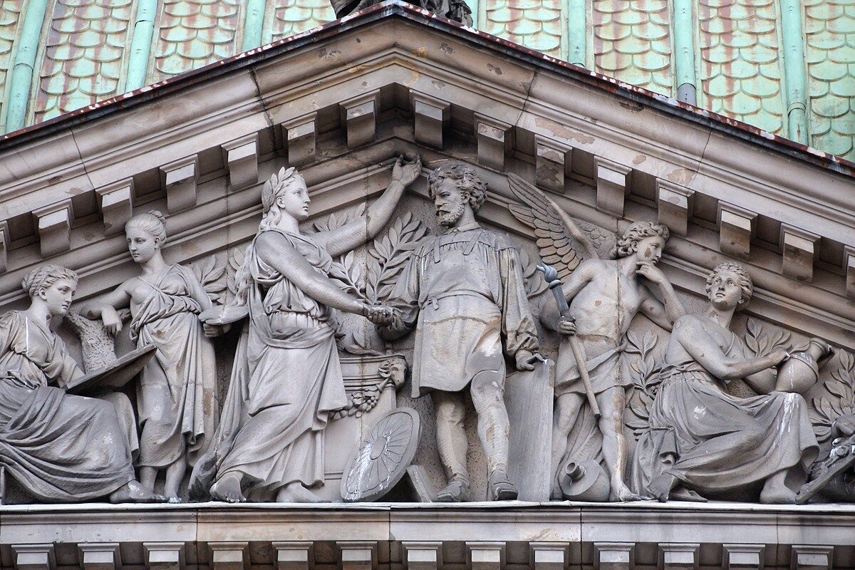 Верхняя часть фронтона Академии, мужчина в фартуке и с бородой внешне напоминает самого Месмахера, первого директора училища