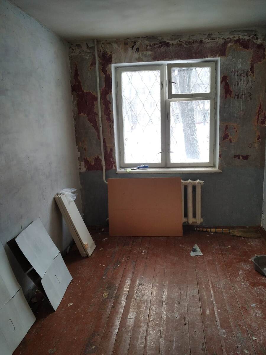 Как видно, краска с досок слезла, стены тоже не обработаны, на батареи виднеться ржавчина.