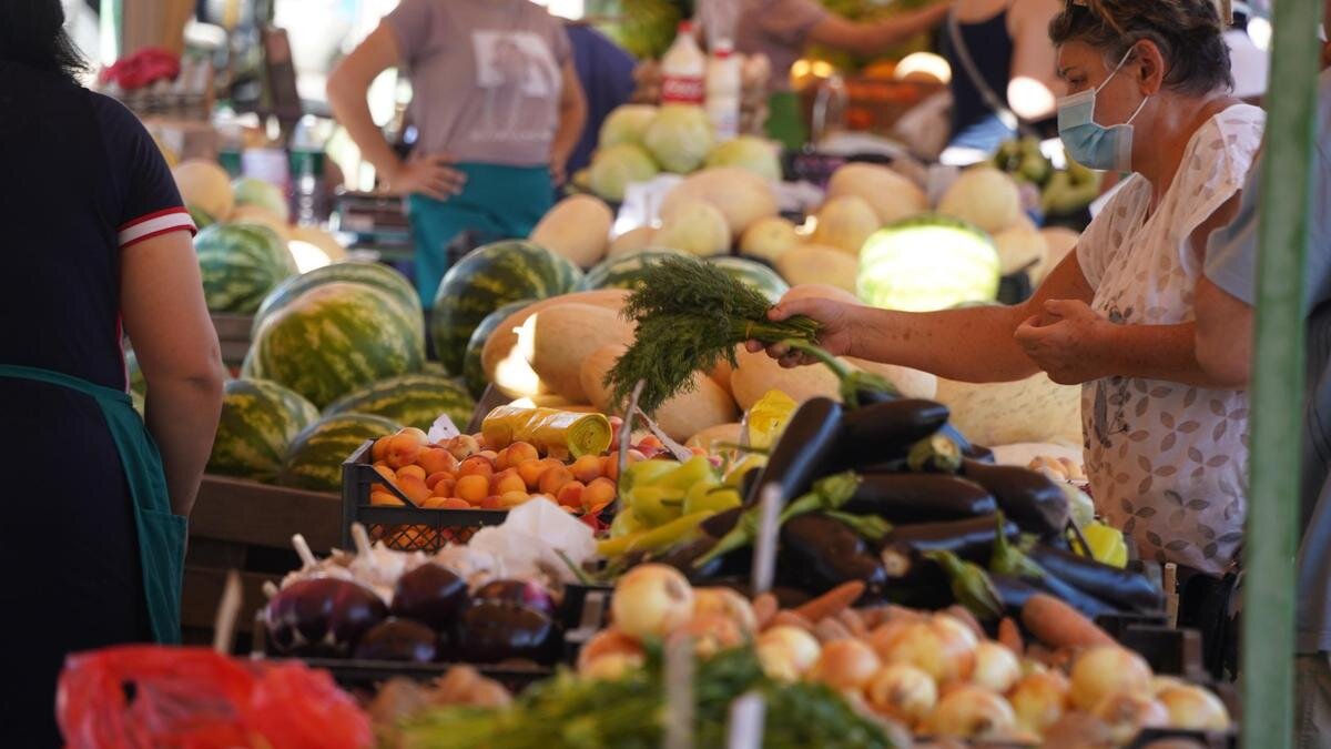    Женщина покупает зелень на базаре.:NUR.KZ/Владимир Третьяков