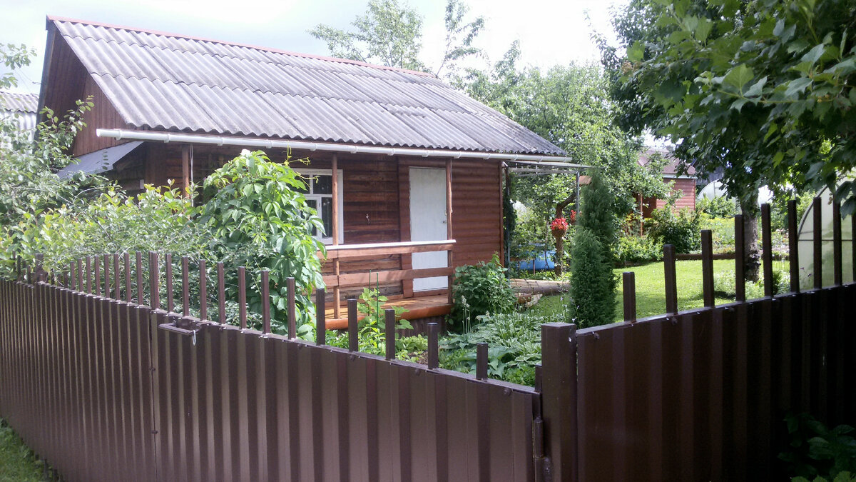 Вид на садовый домик, парадный цветник и центральную лужайку.