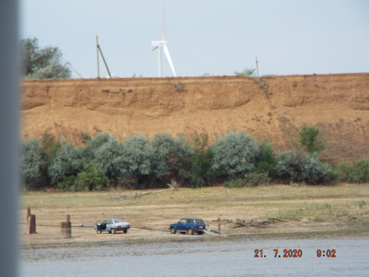 Занятно, однако. Под обрывом местные жители коптят рыбу в древних дровяных коптильнях прямо на берегу, а на горе современный ветрогенератор.