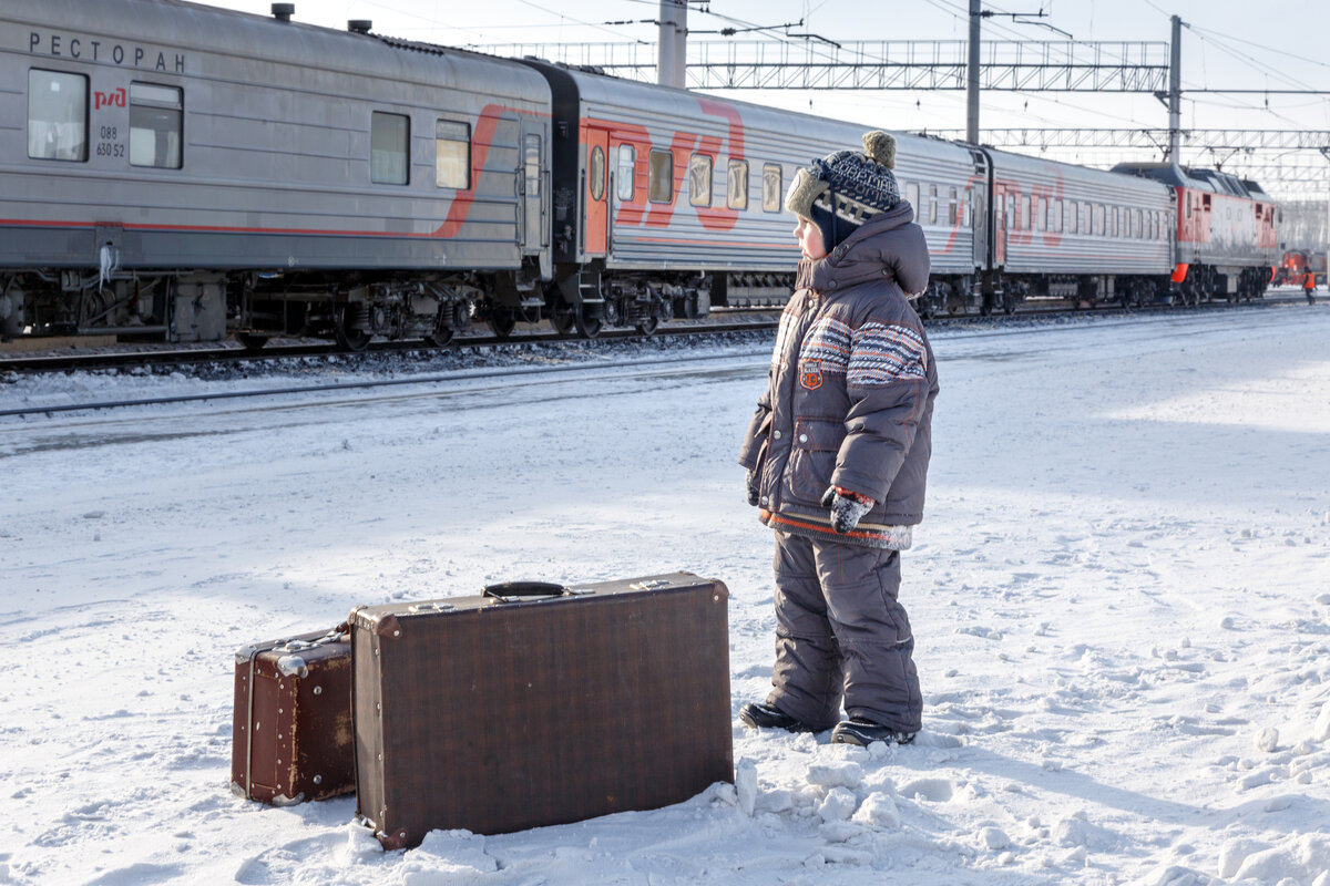 Забавный ребенок на вокзале в ожидании своего поезда. Интересно, что в этих старомодных чемоданах? Фото автора.