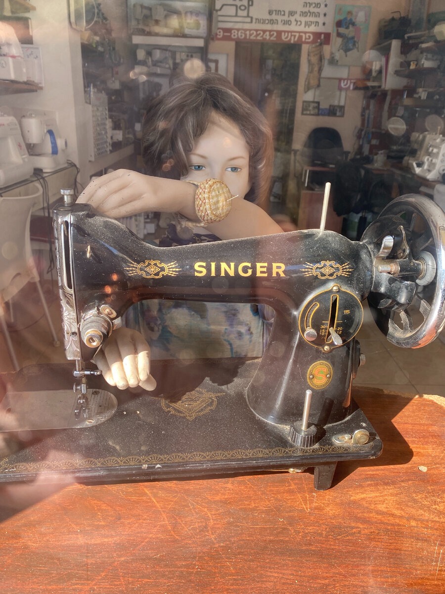 Такая вот девочка со старинной швейной машиной Zinger украшает витрину магазина швейных машин и принадлежностей на улице Анатея 🙂