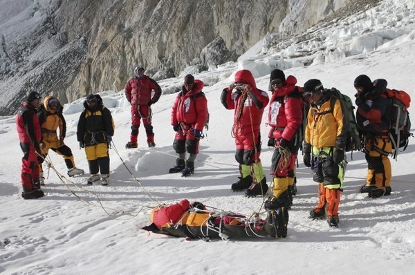 Kelompok pemandu lokal dari etnis Sherpa berdiri di hadapan jenazah rekannya yang terkena salju longsor di Gunung Everest -- NAMGYAL SHERPA / AFP