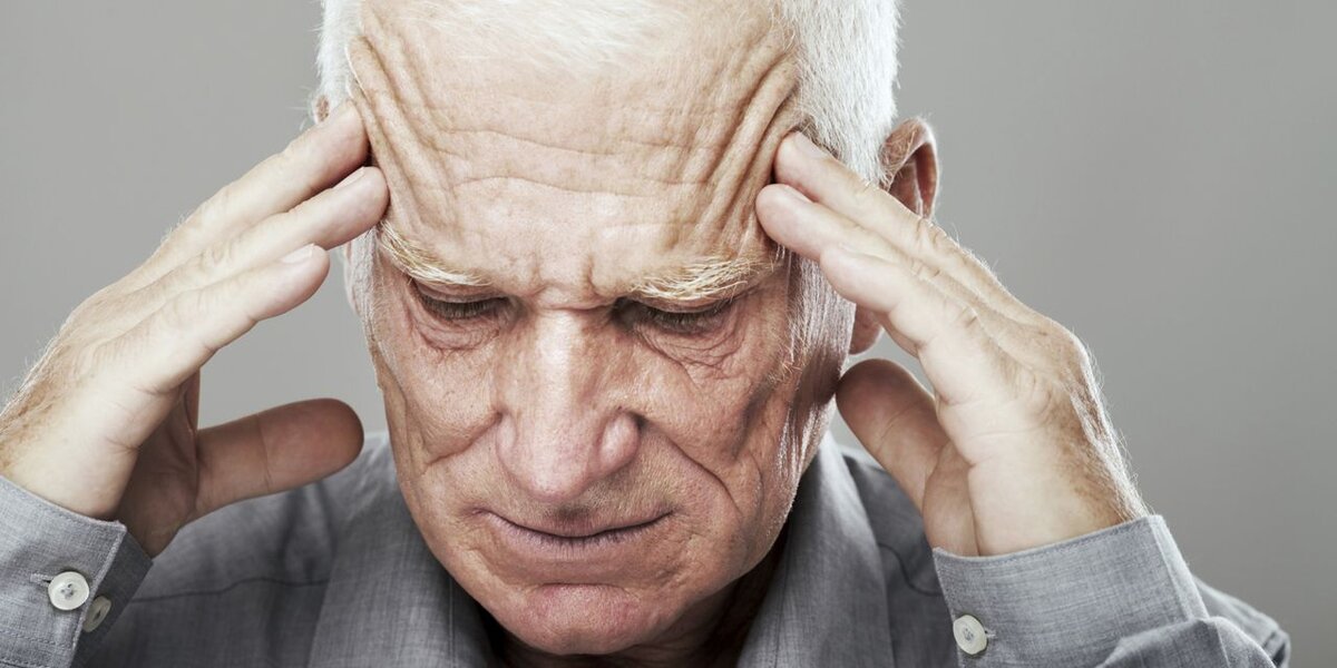 Старческое лицо. Старик болит голова. Головная боль у пожилого. Старик держится за голову.