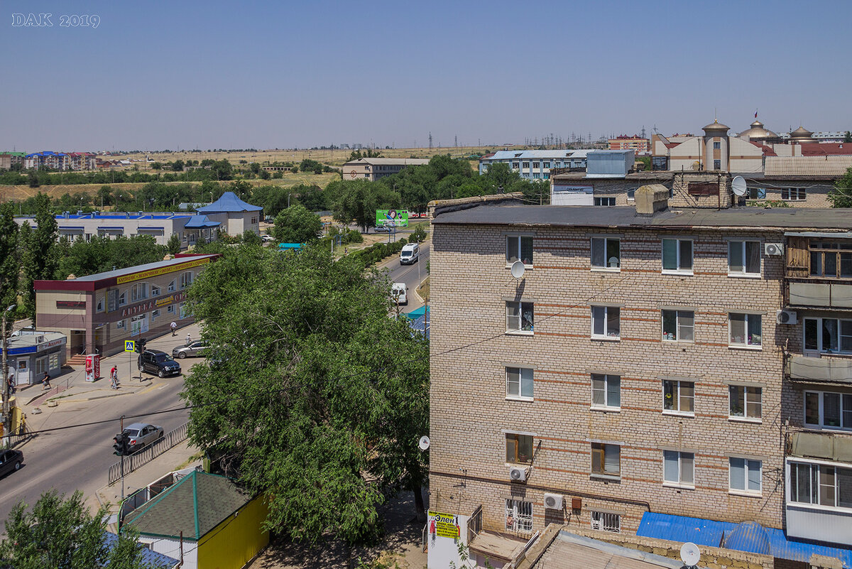 За пятиэтажкой виден шпиль Верховного суда Калмыкии и Политехнический колледж