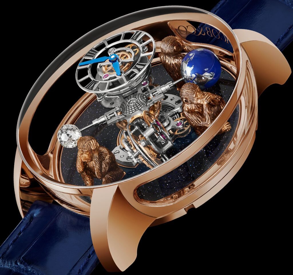 
Часы  Astronomia 3 Wise Monkeys от Jacob & Co. Корпус из розового золота с  сапфировыми стеклами, титановый механизм, двухосевой турбийон,  бриллиант 1 карат с эксклюзивной огранкой, фигуры обезьян из розового  золота, диаметр корпуса 50 мм, толщина 25 мм, водостойкость до 3 атм  (погружение на 30 м). Ремешок из кожи аллигатора с золотой фурнитурой.