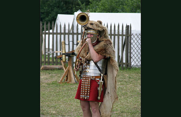 Римский легионер в доспехах с армейским поясом, на который прикреплен кинжал пугио