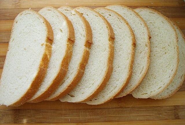  Берем батон.  Режем на ломтики.  Помидор и колбасу режем на кусочки. Зелень(по желанию) измельчаем. 