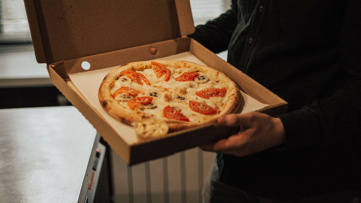 Иллюстрация из источника: https://www.pexels.com/photo/person-holding-pizza-in-box-5056830/