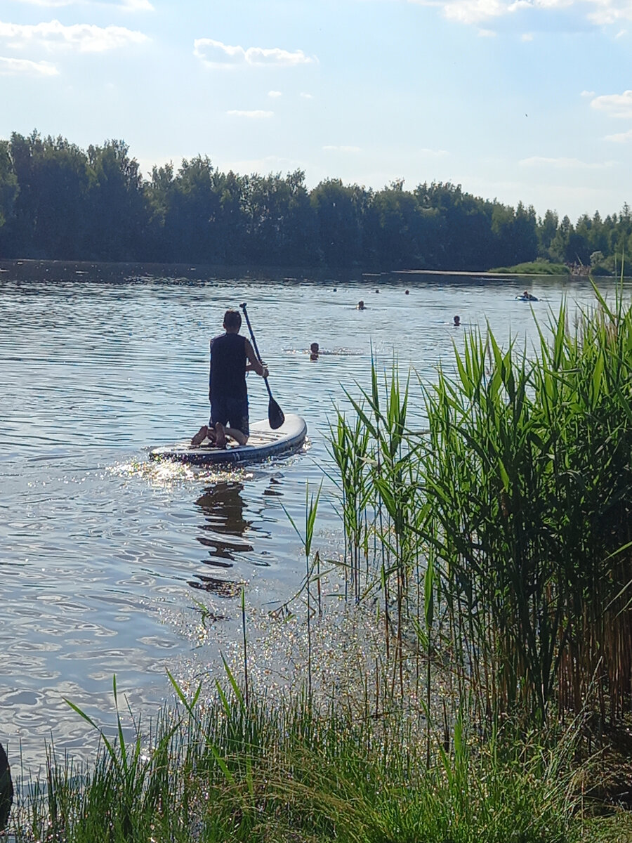 Живописное озеро в форме сердечка, окружённое вокруг лесом. 