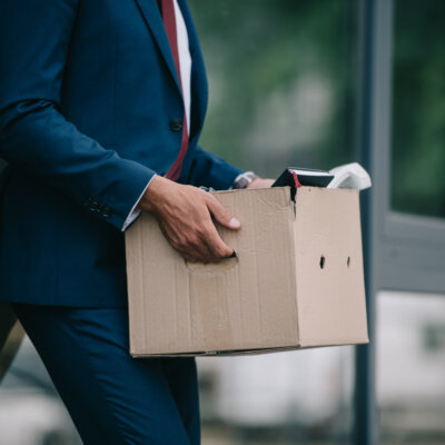    cropped view of fired businessman standing near building and holding carton box Валерий