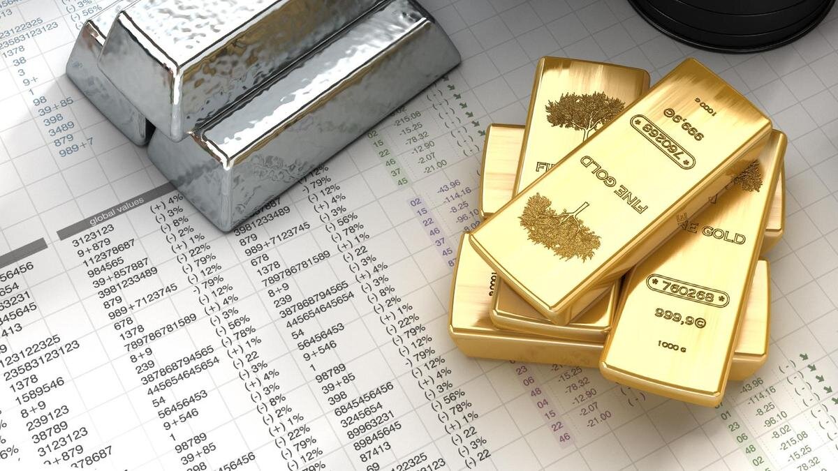    Золотые и серебряные слитки лежат на документах:adventtr/Getty Images