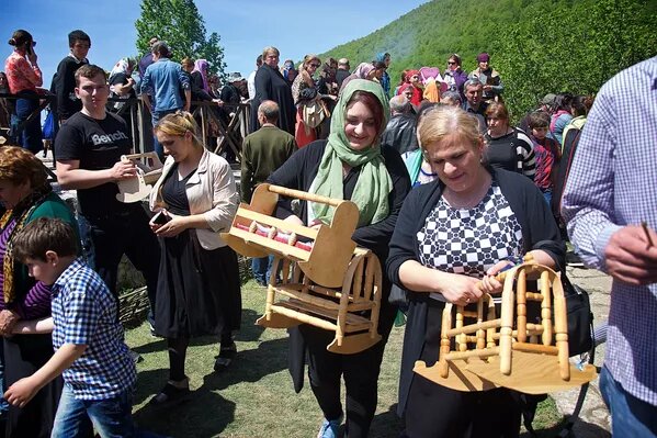 Люди несут в церковь традиционные грузинские колыбели - "аквани"