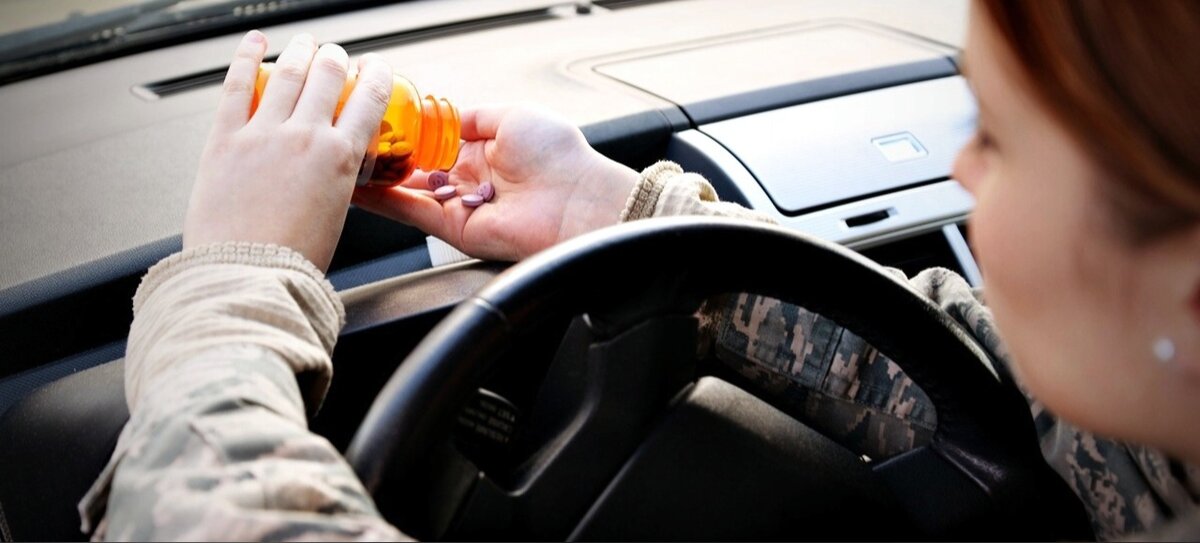 Девушка пьёт таблетки за рулём