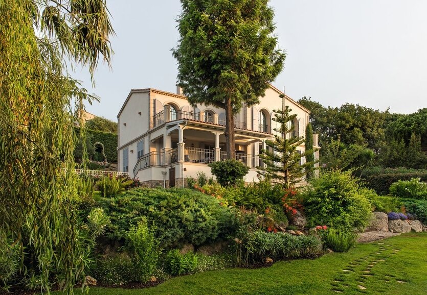 Здесь и далее фото G. De Laubier. Двухэтажный дом, в цоколе которого разместили блок хозяйственных помещений, возвышается в центре многоуровневого участка и окружён живописным садом.