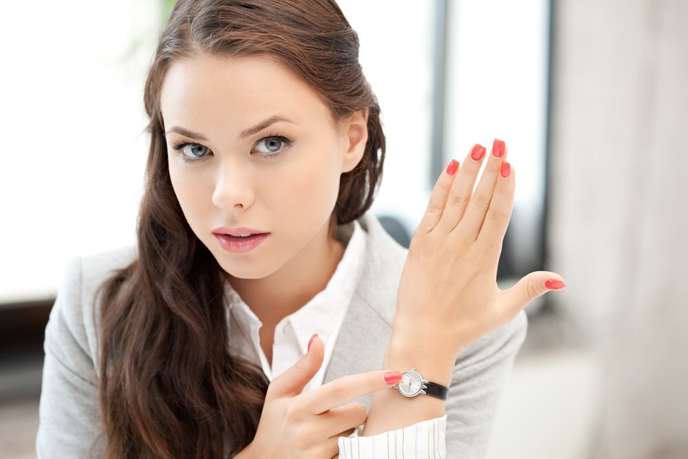 Женщина смотрит на часы. Девушка показывает на часы. Часы для деловой девушки. Пунктуальная девушка. Женщина смотрит на наручные часы.