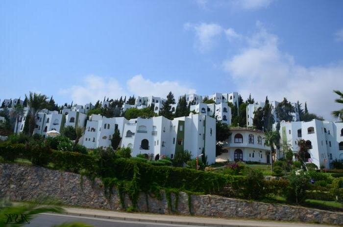 Это знаменитый коттеджный посёлок "Султанели" на границе Тюрклера и Авсалара. Построен каким-то именитым архитектором, ярым поклонником Антонио Гауди и Фриденсрайха Хундертвассера. Великолепный прямой вид на море из каждой виллы. Не дай бог вам в это вляпаться. Я там бывал в гостях, не выдержал и трёх часов пребывания.