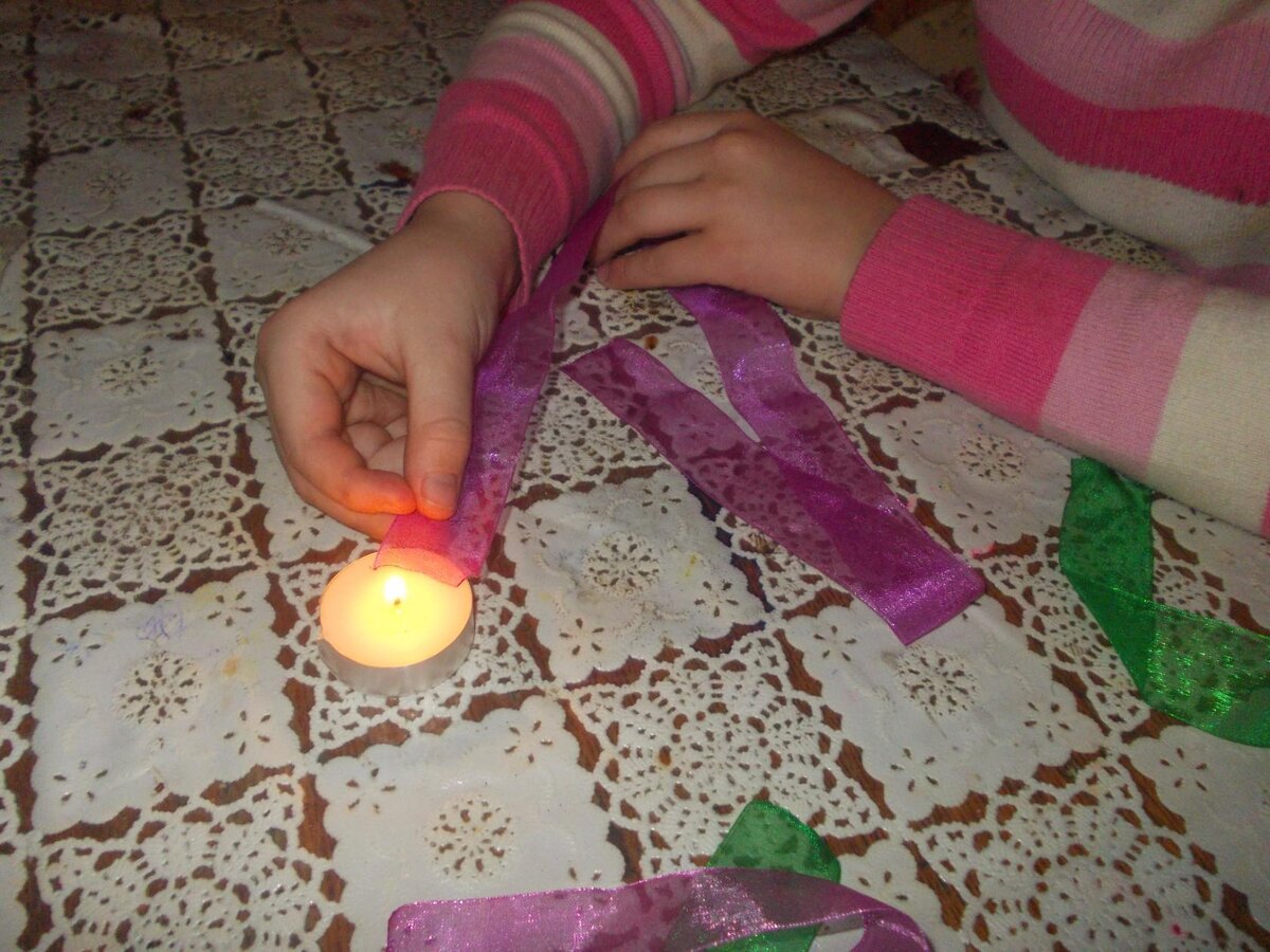 Ленту отрезаем по 30 сантиментров, края аккуратно опаливаем над свечой