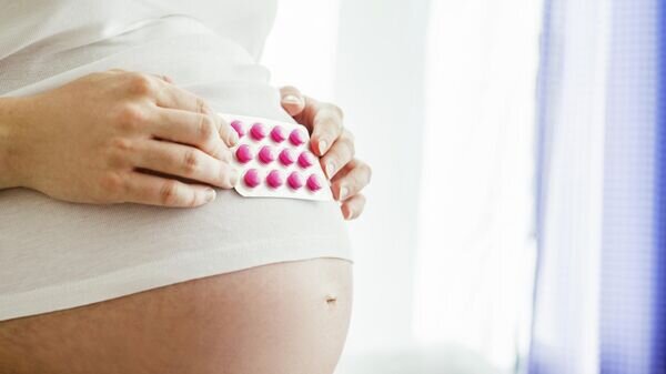    Беременная женщина с витаминами© Depositphotos / halfpoint