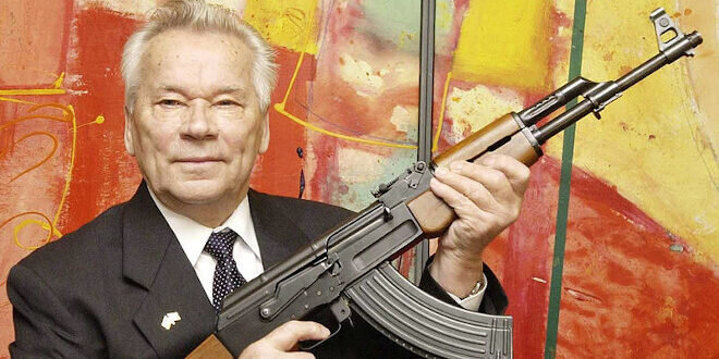 Михаил Калашников представляет АК - 47 на выставке.