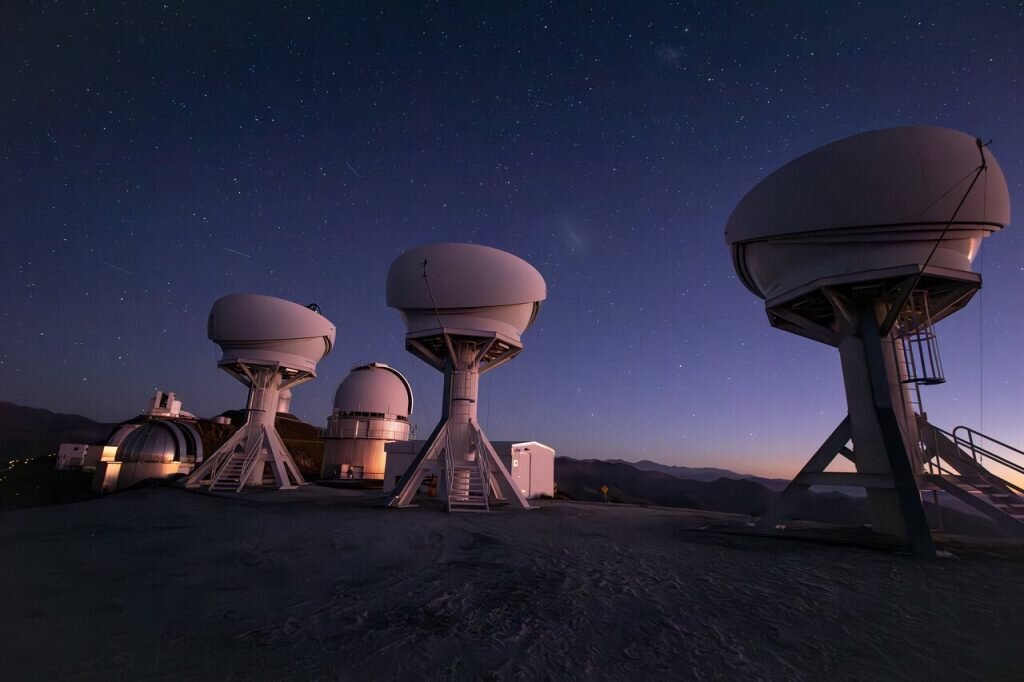    The BlackGEM array, consisting of three new telescopes located at ESO’s La Silla Observatory, has begun operations. This photograph shows the three open domes of the BlackGEM telescopes under a stunning night sky a La Silla. Other telescopes at the observatory are visible in the background. Александр Шереметьев
