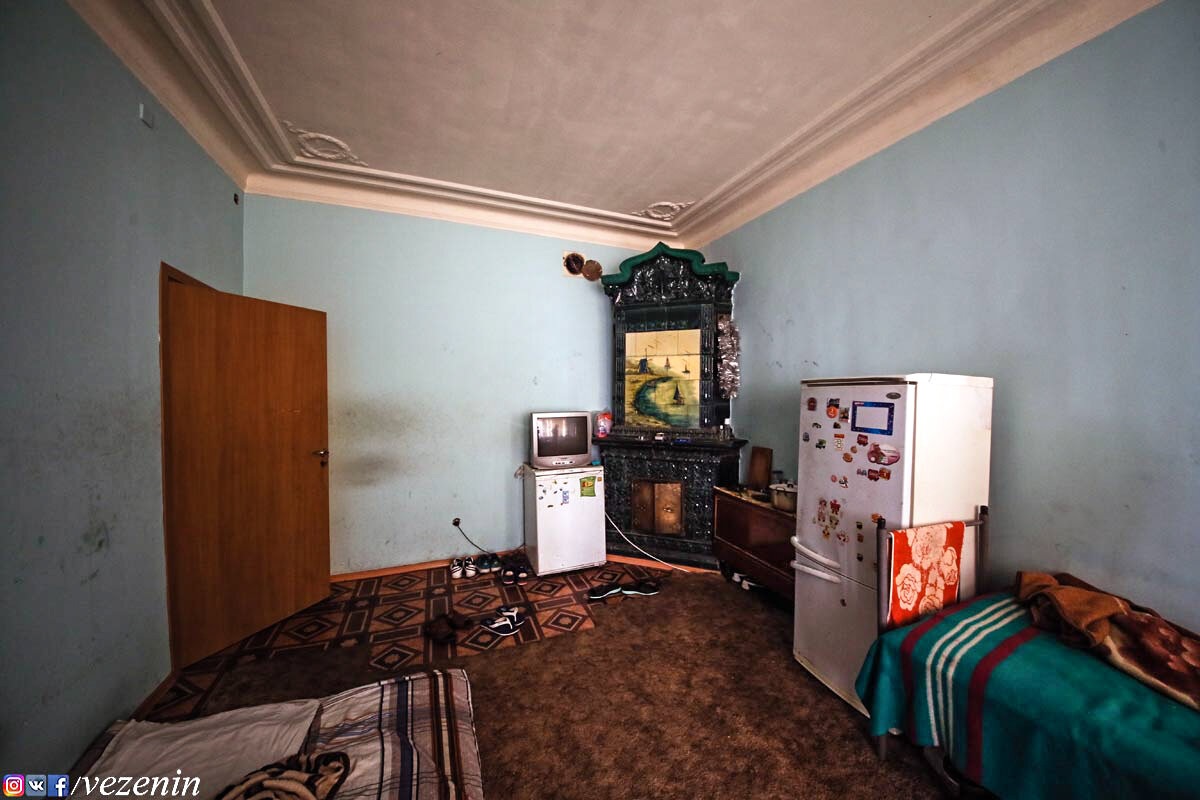 Скромное убранство коммунальной комнаты компенсирует редкой красоты печь.