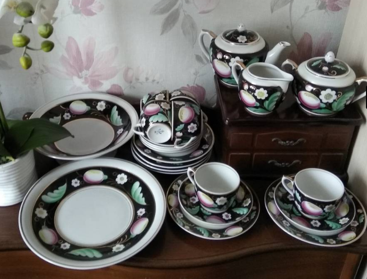 На фото видны множество предметов сервиза росписи "Слива" на чёрном по форме "Стандарт". Это не только три "больших" предмета и чайные пары, но и тарелки, и блюда-сухарницы. Фото взято из свободного доступа в интернете. Листайте галерею дальше!