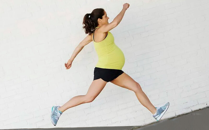 Счастливая бегущая беременная девушка