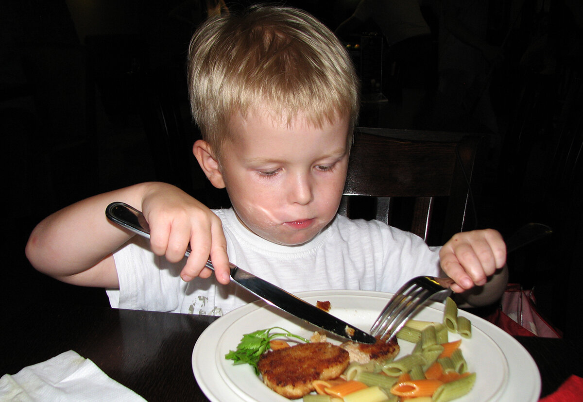 Фото стол пацана. Ест вилкой и ножом. Ребенок ест ножом и вилкой. Человек ест котлету. Мальчик ест котлету.