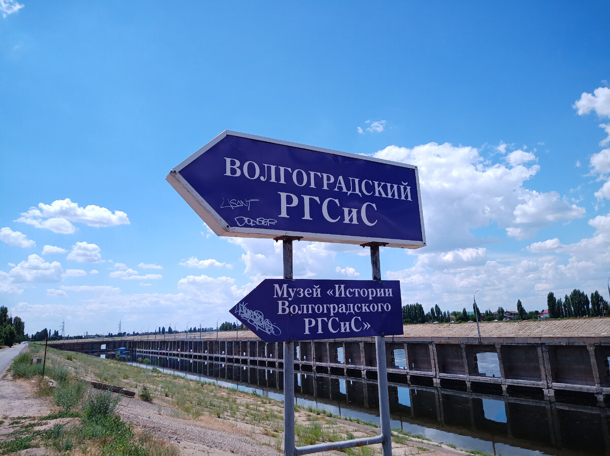 Сразу за указателем видна причальная стенка у подходного канала, по которому суда проходят к шлюзам