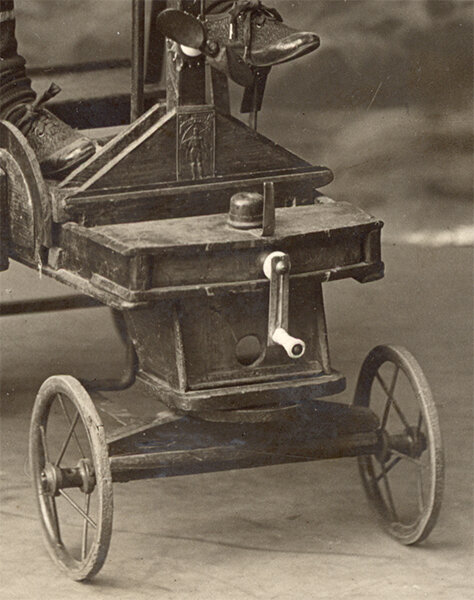 Фотография 1917 года из коллекции Веломузея Андрея Мятиева, запечатлевшая ребенка на игрушечном автомобиле с ручным приводом.