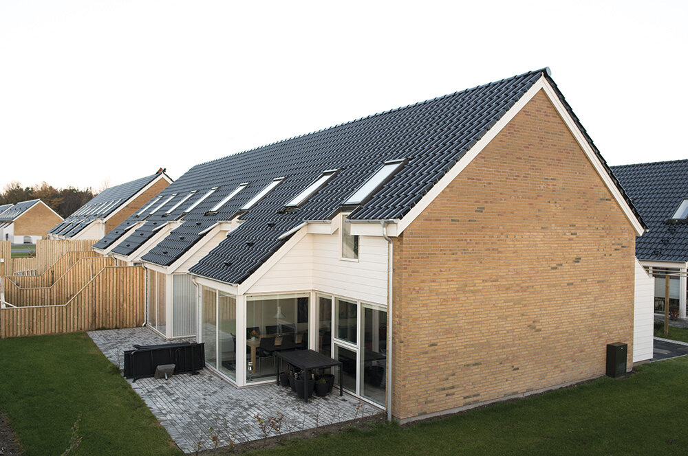 Тёмная металлочерепица в обрамлении мансардных окон выглядит очень стильно