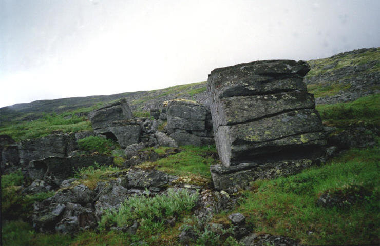 Горы Русской Лапландии в Заполярье. В глухой Ловозерской тундре найдены циклопические руины и стены, гигантские плиты правильной геометрической формы с пропилами техногенного происхождения, просверленные глыбы, ритуальный колодец, таинственные знаки и письмена.