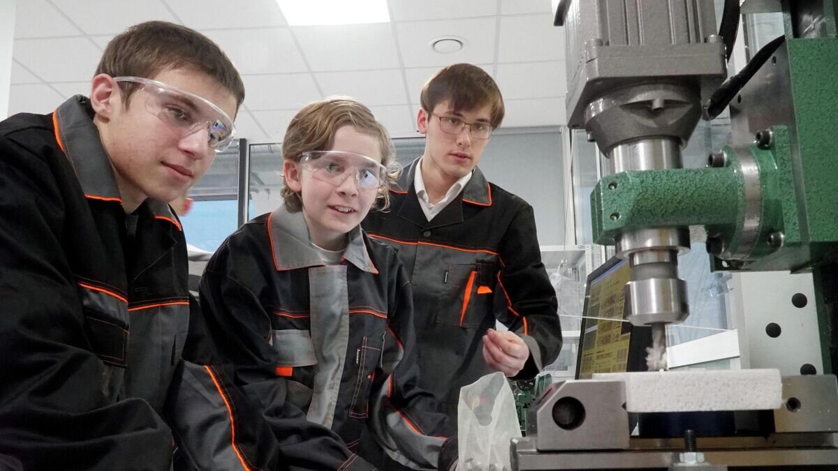    Школьники и студент у фрезерного станка с ЧПУ в производственном секторе Фаблаба© РИА Новости / Игорь Зарембо