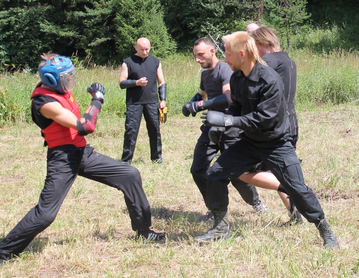 Бойцы атакующего звена выстроились стенкой, стремясь выбить охотника за край площадки. Турнир по засечному бою в Перуновой Слободе, июль 2016.