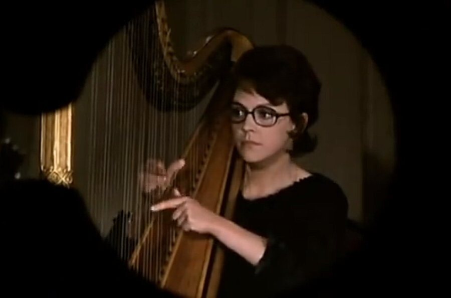 Мало того, что арфистка, так и еще француженка из 70-х. Кадр фильма "Высокий блондин в черном ботинке", скриншот.