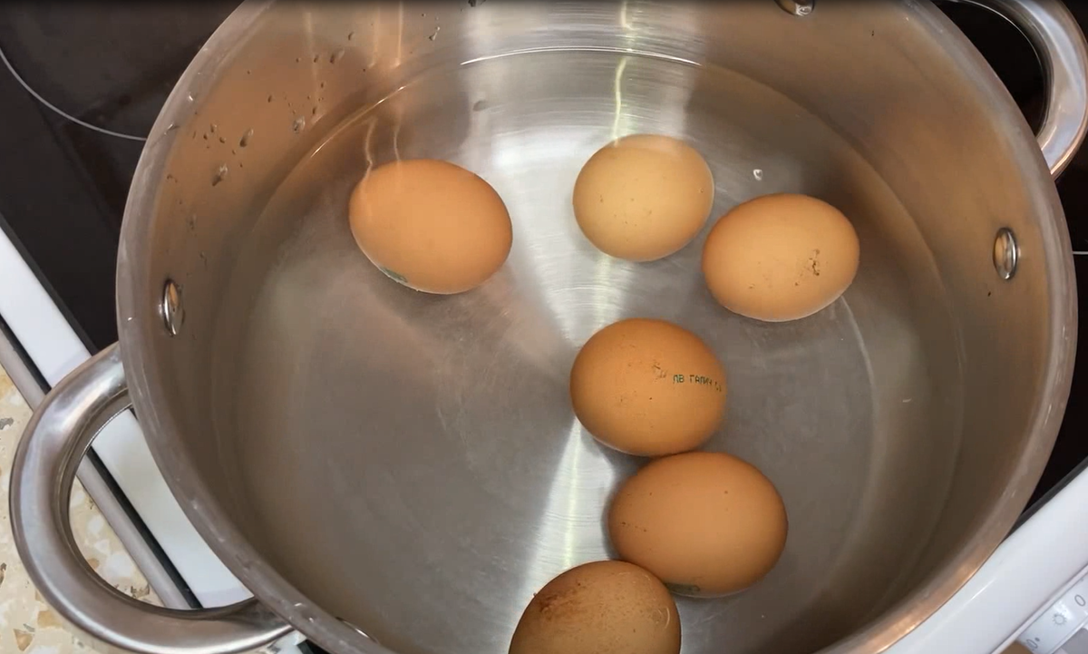 Шесть куриных яиц, положите в кастрюлю и залейте холодной водой. Яйца довести до кипения и варить примерно еще 8 минут.