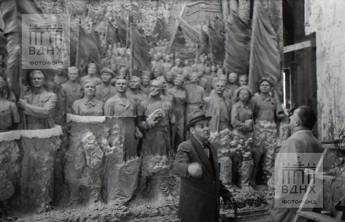 Снимок относится к 1950-1954-м гг., сделан в мастерской. Первый слева на фотографии - Вучетич Евгений Викторович - руководитель коллектива скульпторов, создавших горельеф "Знаменосцу мира, советскому народу - слава!"