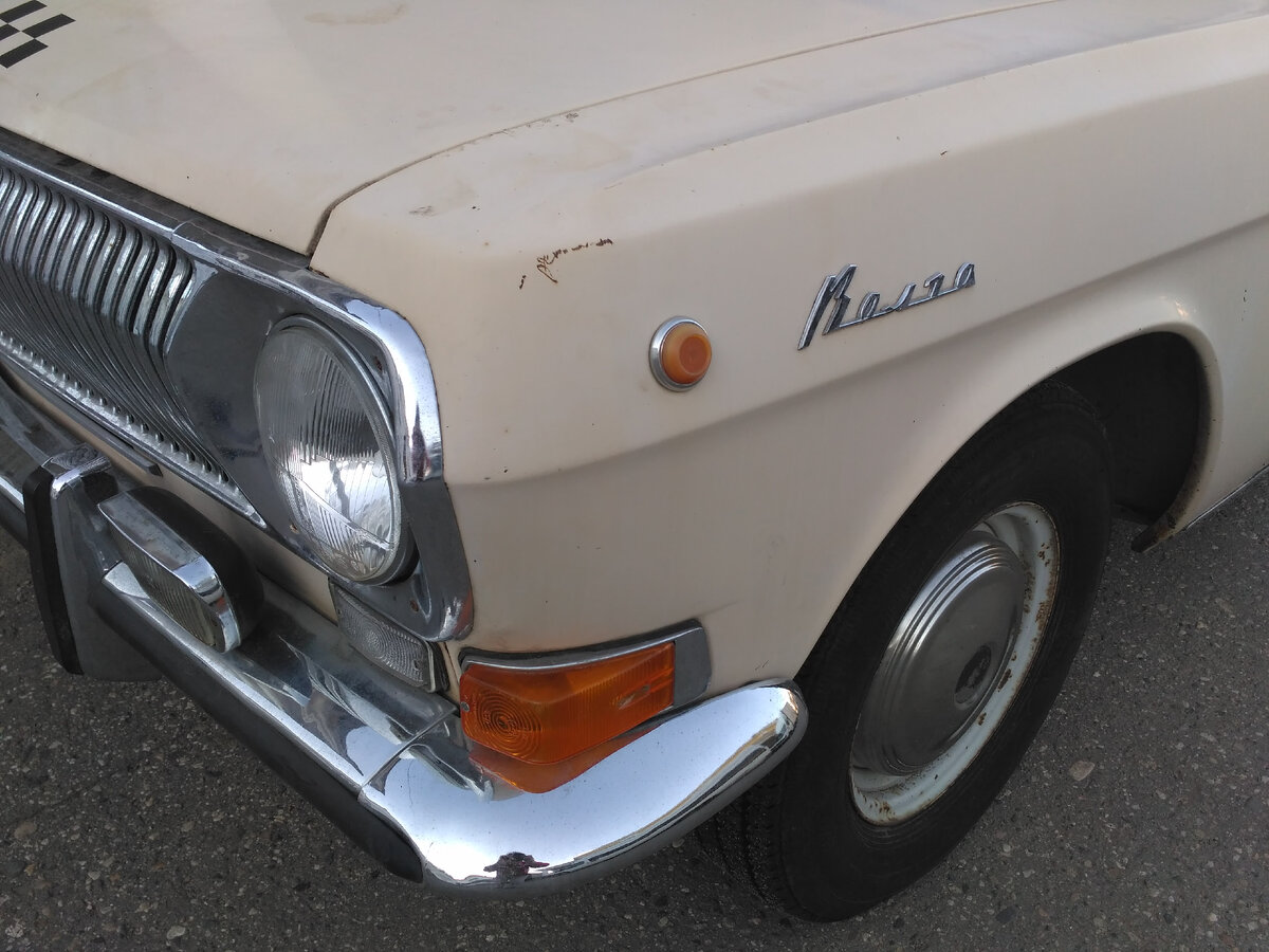 Шильдик "Волга" на крыле машины.