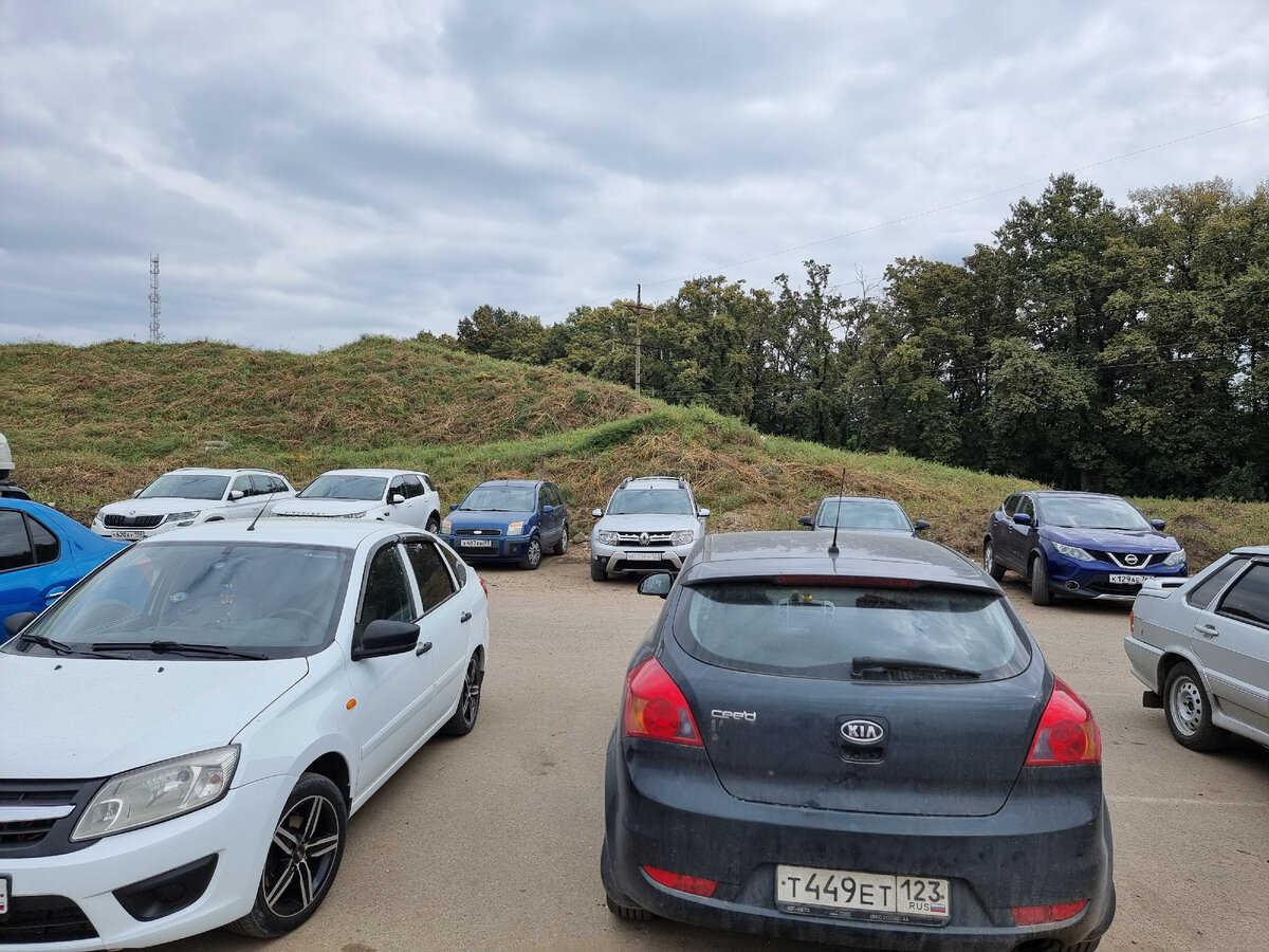 У холмика за вторым рядом машин горы мусора