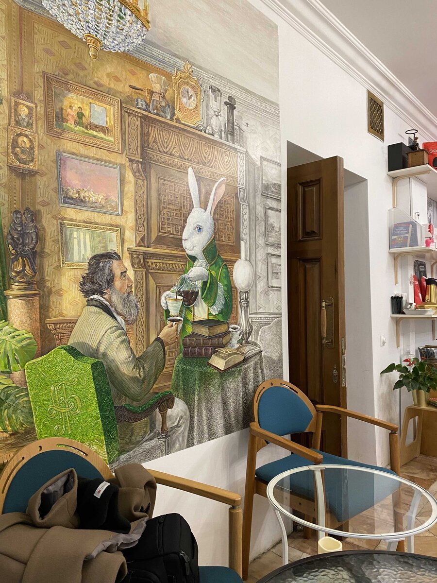 На стенах тут видимо сцена с Льюисом Кэрроллом и кроликом из его книги
