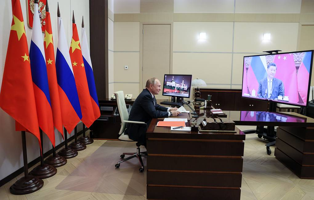 Президент РФ Владимир Путин и председатель КНР Си Цзиньпин (на экране) (© Михаил Метцель/POOL/ТАСС)